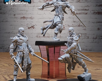 May include: Three gray miniature ninja figurines in dynamic poses, each holding a katana. The figurines are on black circular bases. The top left corner of the image has the text "EPIC Miniatures" in blue and white.