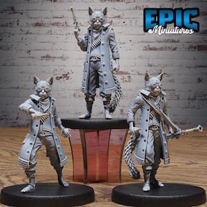 May include: Three gray cat-like figurines in a steampunk style, each with goggles, coats, and weapons. One figure stands on a platform, while the others are on black bases. The Epic Miniatures logo is visible in the upper right corner.