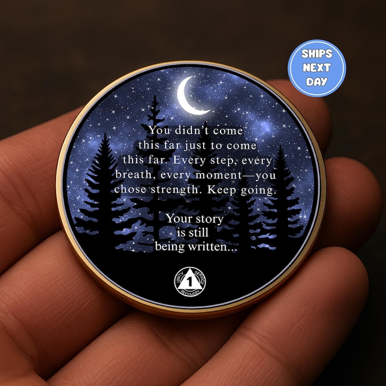 May include: A round, gold-toned coin featuring a night sky scene with a crescent moon, stars, and silhouetted trees. The coin has inspirational text: "You didn't come this far... Keep going. Your story is still being written..."