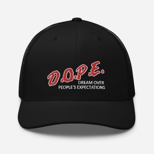 May include: Black trucker hat with a red embroidered logo that says "D.O.P.E. DREAM OVER PEOPLE'S EXPECTATIONS"