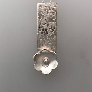 Silver Flower on embossed Bar.