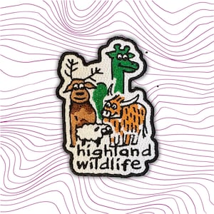 Può includere: Toppa ricamata con animali dei cartoni animati: un cervo, una giraffa, una pecora e una mucca delle Highlands. La toppa ha un bordo nero e le parole "highland wildlife" in bianco. Lo sfondo è bianco con linee di contorno viola.