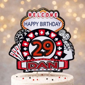 Può includere: Un topper per torta a tema casinò con un'insegna che recita WELCOME HAPPY BIRTHDAY, una grande grafica della ruota della roulette con il numero 29 al centro, carte da gioco, dadi, fiches da poker e un banner con il nome DAN in lettere rosse.