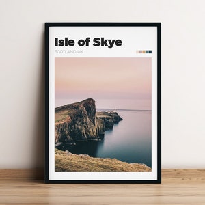 May include: A black framed print with the text "Isle of Skye, SCOTLAND, UK" and a photograph of a rocky cliff overlooking a body of water. The sky is a soft pink and purple.