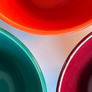 Puede incluir: Tres cuencos de cer&aacute;mica, uno rojo, uno verde y uno burdeos, est&aacute;n dispuestos en forma de tri&aacute;ngulo. Los cuencos est&aacute;n vac&iacute;os y parecen nuevos.
