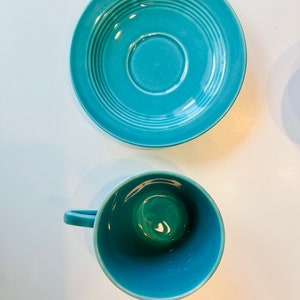 Puede incluir: Un juego de taza y platillo de color azul turquesa. El platillo tiene un dise&ntilde;o acanalado y la taza tiene un interior liso.