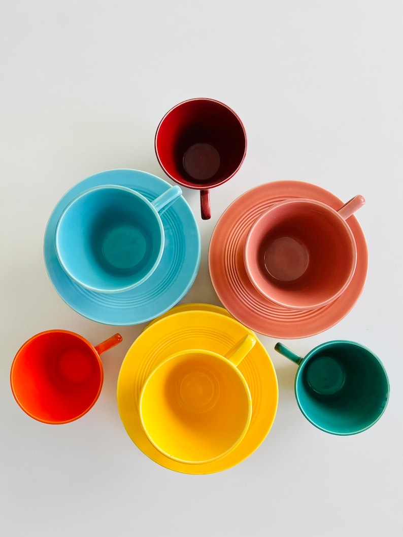 Puede incluir: Seis tazas de t&eacute; y platillos coloridos en un patr&oacute;n de arco&iacute;ris. Las tazas y los platillos est&aacute;n dispuestos en un c&iacute;rculo sobre un fondo blanco. Los colores son rojo, naranja, amarillo, verde, azul y rosa.
