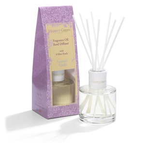 May include: A lavender and vanilla scented reed diffuser with 8 fibre reeds. The diffuser is in a clear glass bottle with a white cap and the Hassett Green London logo. The bottle is sitting on a white surface. The diffuser is packaged in a purple box with a floral design and the text "Fragrance Oil Reed Diffuser with 8 Fibre Reeds Lavender Vanilla".