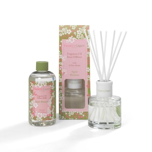 May include: A Hassett Green Apple Blossom fragrance oil diffuser set. The set includes a glass bottle with reeds, a refill bottle, and a box. The bottles are clear, and the box is decorated with a floral pattern. The refill bottle contains 250 ml of fragrance oil.