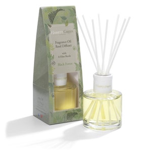 May include: A clear glass bottle with a white lid and a label that reads "Hassett Green London Fragrance Oil Reed Diffuser with 8 Fibre Reeds Black Forest". The bottle is filled with a yellow liquid and has white reeds sticking out of the top. The bottle is sitting on a white surface.