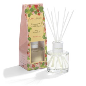 May include: A pink and green box with a picture of strawberries on it. The box contains a clear glass bottle with a white lid and a set of white reeds. The bottle is labelled "Hassett Green London Fragrance Oil Reed Diffuser with 8 Fibre Reeds Strawberry".