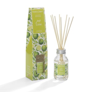May include: A glass bottle diffuser with a silver lid and wooden sticks. The bottle is filled with a clear liquid and has a label that says "Hassett Green Just Lime". The bottle is sitting on a white surface.
