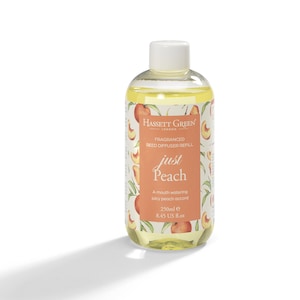May include: A clear glass bottle containing a yellow liquid. The bottle has a white cap and a label that reads "Hassett Green London Fragranced Reed Diffuser Refill Just Peach A mouth watering juicy peach accord 250ml e 8.45 US fl.oz". The label features a peach design.