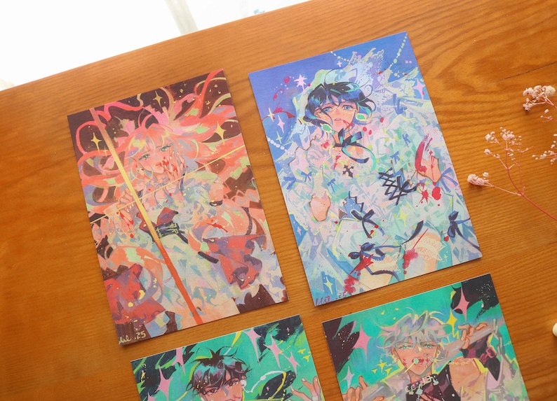 May include: Four art prints displaying colourful anime-style illustrations. The prints feature characters with vibrant hair and clothing, set against dynamic backgrounds with splashes of colour. The artwork has a fantasy theme.