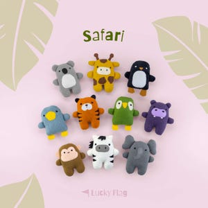 May include: A collection of ten small, plush animal figures arranged on a light pink background. The set includes a koala, giraffe, penguin, blue bird, tiger, green bird, hippo, monkey, zebra, and elephant. The text Safari and Lucky Flag appear.