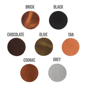 May include: A leather notebook with a black elastic closure and a flap with a leather strap. The notebook is available in 10 colors: Brick, Black, Chocolate, Olive, Tan, Cognac, Grey, Navy, Burgundy, and Natural.