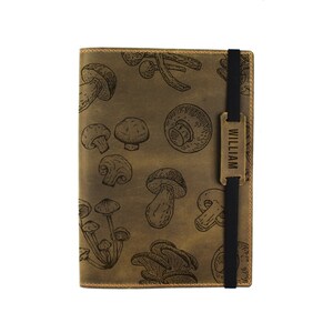 May include: A brown leather journal with a mushroom pattern and a personalised brass nameplate that reads "WILLIAM".