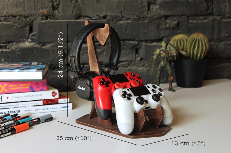 May include: Wooden stand with a headset, two video game controllers, and measurements in inches and centimeters.