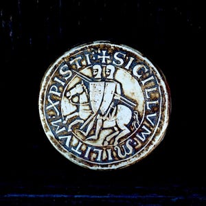 May include: A round, white seal with a raised image of a knight on horseback. The seal is inscribed with the words "SIGILLVM", "WILLELMI", "PISTI", and a cross.