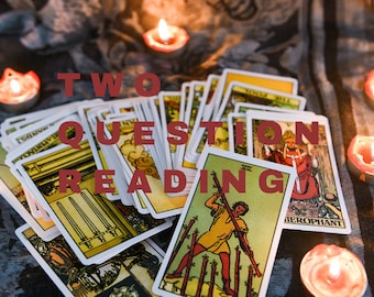 Puede incluir: Una lectura de tarot con el texto "TWO QUESTION READING" encima de una pila de cartas de tarot. Las cartas están rodeadas de velas de té encendidas sobre una superficie de tela estampada.