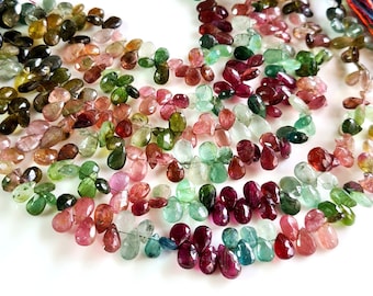 Peut inclure: Un brin de perles de pierres précieuses multicolores, présentant une variété de nuances de vert, de rose et de rouge. Les perles sont facettées et ont une forme de larme.