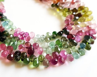 Peut inclure: Un brin de perles de pierres précieuses facettées dans différentes nuances de rose, de vert et de brun. Les perles sont en forme de goutte et ont une finition polie.