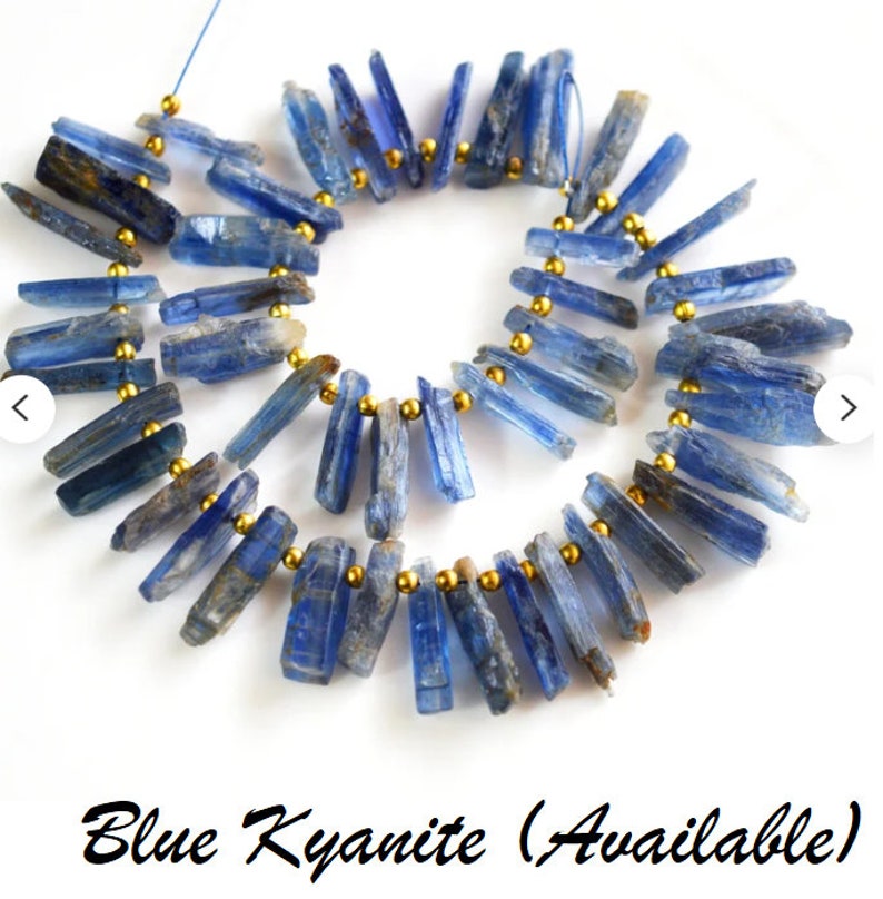 May include: A strand of blue kyanite gemstone beads strung on gold wire. The beads are long and slender, with a slightly rough texture.  Blue Kyanite (Available)