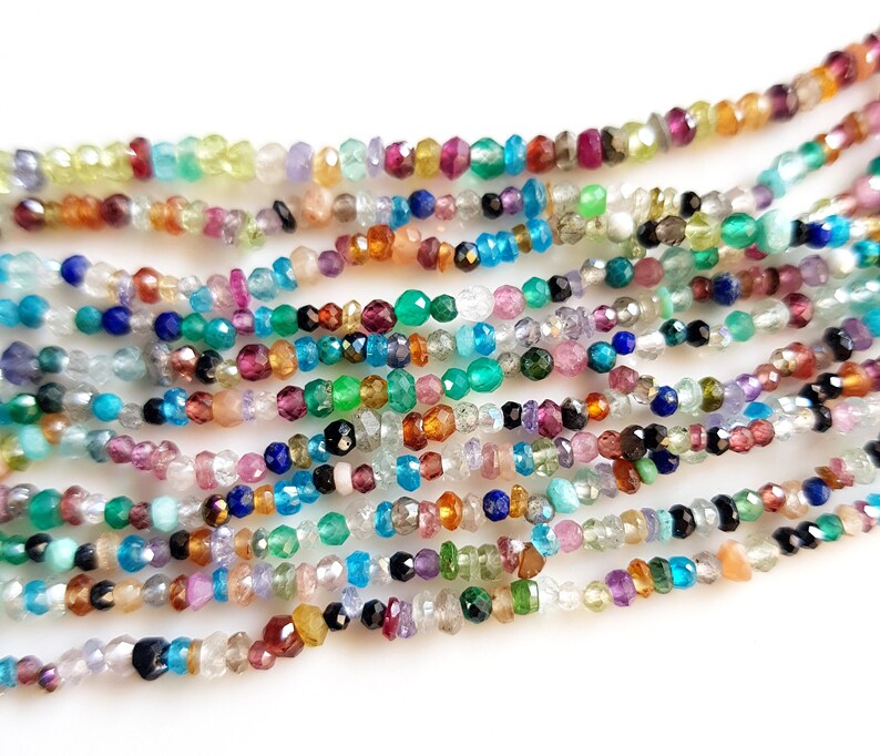 May include: A strand of colorful gemstone beads, including aquamarine, amethyst, garnet, and citrine. The beads are faceted and have a variety of shapes and sizes.