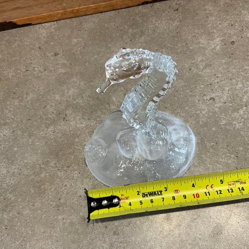 May include: A clear glass seahorse figurine with a textured base. The figurine is approximately 4 inches tall.