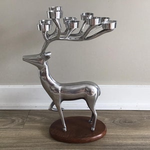 May include: Silver reindeer candle holder with a wooden base and seven candle cups.