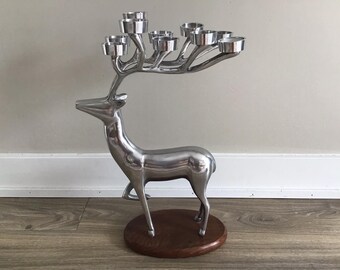 May include: Silver reindeer candle holder with a wooden base and seven candle cups.