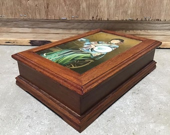 May include: A wooden jewelry box with a glass top featuring a painted image of a woman in traditional Chinese clothing holding a fan.