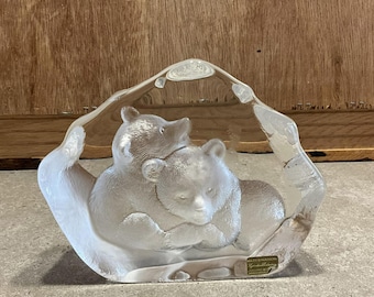 May include: A clear glass sculpture of two bears, one sitting on top of the other, with the text "WATERFORD SIGNATURES" on the bottom.