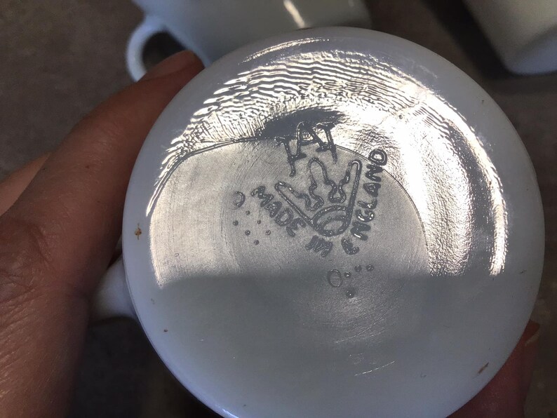 Pode incluir: Caneca de cer&acirc;mica branca com um logotipo preto e branco que diz "Made in England" e uma coroa.