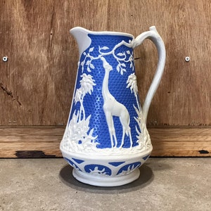 Vintage Blue and White Pitcher with Giraffe Animal Decorations.