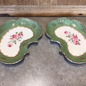 May include: Two green and gold serving dishes with a white centre and pink rose floral design.