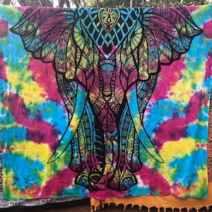 May include: A colourful tie-dye tapestry featuring a black and white mandala-style elephant design. The tapestry has a blue, pink, yellow, and green colour scheme.
