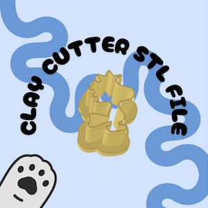 May include: A gold-colored clay cutter in the shape of a unicorn, with the text "CLAY CUTTER STL FILE" in black. The background is light blue with blue wavy lines and a cartoon paw print.