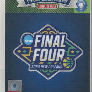 Op de afbeelding: Een blauwe en witte patch met de tekst "NCAA FINAL FOUR 2022 NEW ORLEANS" in een wit, geel en groen ontwerp. De patch is omgeven door een zilveren rand.