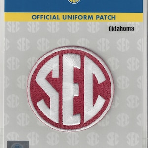 May include: A red and white embroidered patch with the letters SEC in a circle. The patch is labeled "Official Uniform Patch" and "Oklahoma".