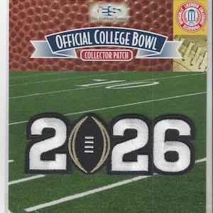 May include: Official College Bowl collector patch with the year 2026 in white and black stitching. The football in the center has a gold border. The background shows a football field.
