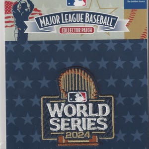 Può includere: Una toppa da collezione della Major League Baseball con il logo delle World Series 2024. La toppa è in una confezione di plastica trasparente con sfondo blu e motivo a stelle. Il logo The Emblem Source è visibile.