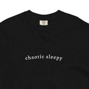 Puede incluir: Camiseta negra con el texto "chaotic sleepy" impreso en blanco en la parte delantera.