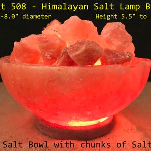 May include: A Himalayan salt lamp bowl with a warm, orange glow. The bowl is filled with large chunks of pink Himalayan salt. The bowl is 7.5 to 8 inches in diameter and 5.5 to 6 inches tall.