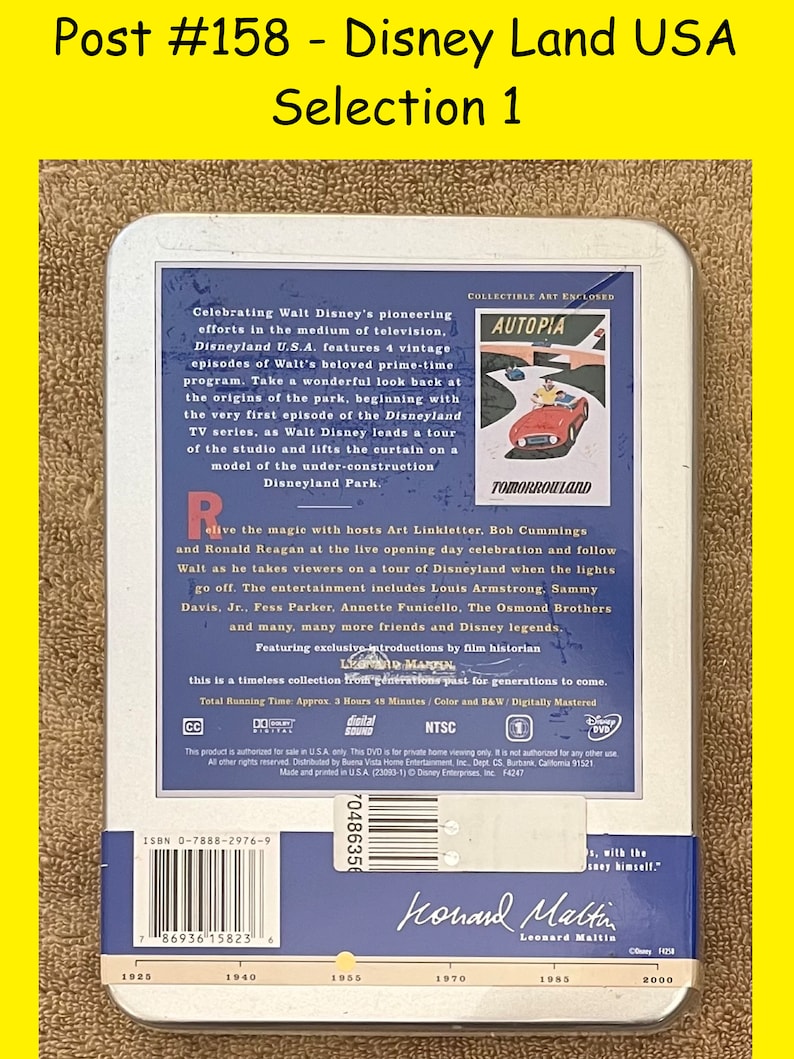 K&ouml;nnte beinhalten: Eine silberne Blechdose mit einem blauen und wei&szlig;en Bild eines roten Autos, das durch eine futuristische Stadt f&auml;hrt. Der Text "Autopia" und "Tomorrowland" ist auf dem Bild zu sehen. Die Dose enth&auml;lt eine DVD der Fernsehserie Disneyland U.S.A. Der Text "Celebrating Walt Disney's pioneering efforts in the medium of television, Disneyland U.S.A. features 4 vintage episodes of Walt's beloved prime-time program." ist auf der Dose zu sehen.