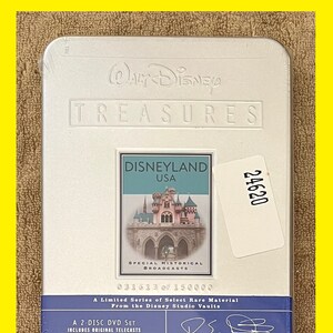 K&ouml;nnte beinhalten: Ein silbernes DVD-Geh&auml;use aus Metall mit einem wei&szlig;en Etikett, auf dem das Walt Disney Treasures-Logo und der Text "Disneyland USA" zu sehen sind. Das Geh&auml;use enth&auml;lt ein Bild von Schloss Dornr&ouml;schen und den Text "Besondere historische Sendungen". Das Geh&auml;use enth&auml;lt auch den Text "Eine limitierte Serie von ausgew&auml;hltem seltenem Material aus den Disney Studio Vaults" und "Urspr&uuml;nglich ausgestrahlt zwischen 1955 und 1970".
