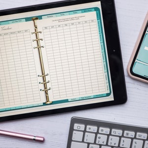 May include: A digital planner app on a tablet screen with a bills tracker page. The page is divided into two sections, one for a list of bills and the other for a calendar view. The calendar view shows the months of the year from January to December. The app is open on a white wooden surface with a keyboard and a stylus.