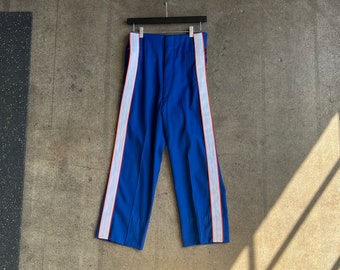 Könnte beinhalten: Blaue Hose mit weißen und roten Streifen an den Seiten.