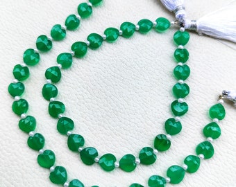 Puede incluir: Una hebra de cuentas de piedras preciosas verdes con acentos de perlas blancas. Las cuentas son facetadas y tienen forma de corazón. La hebra está enhebrada en un cordón delgado y tiene borlas en los extremos.
