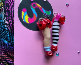 Brincos pendentes de estilo vintage com pernas de boneca inspiradas em Dorothy e na Bruxa Malvada.